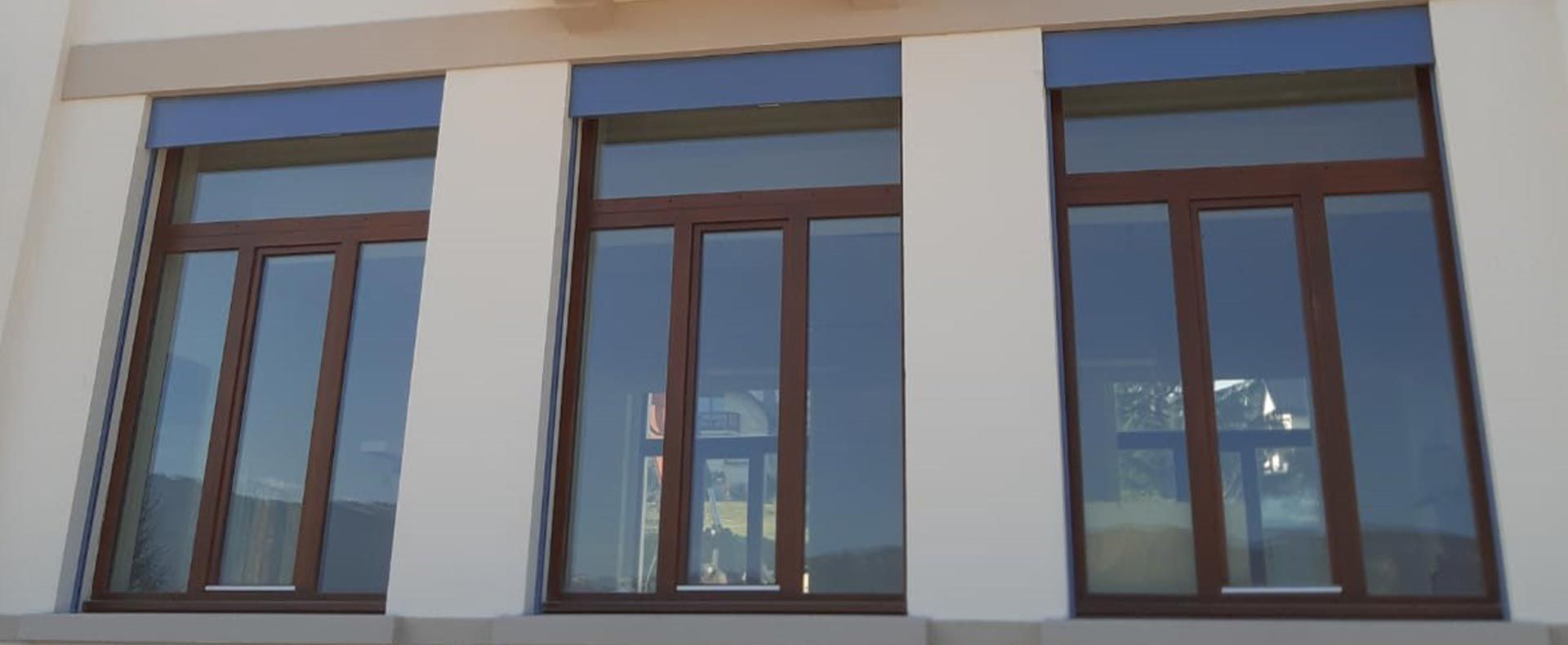 Façade enduite avec fenêtres en bois et balcon